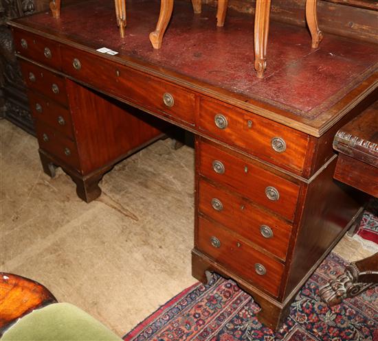 A mahogany nine drawer pedestal desk, with a red, gilt tooled leather inset top